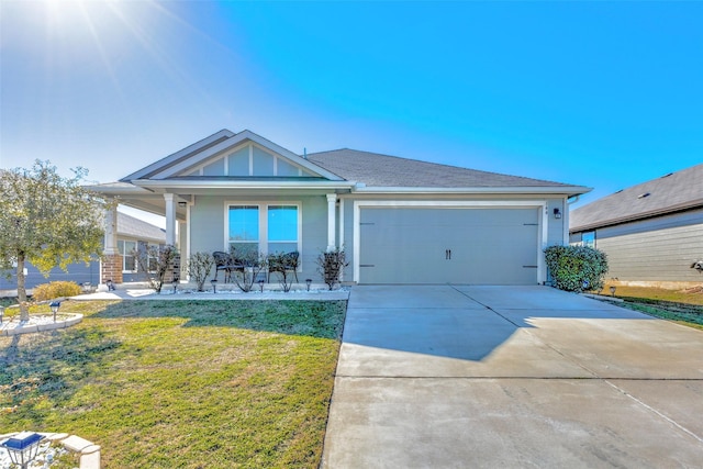 view of front of home featuring a garage, covered porch, and a front yard