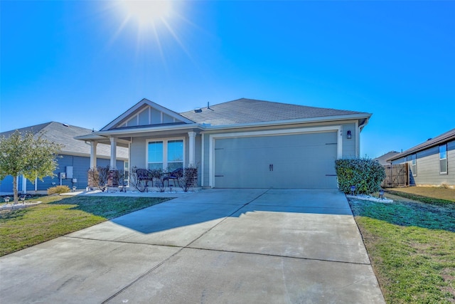 view of front of home featuring a porch, a garage, and a front lawn