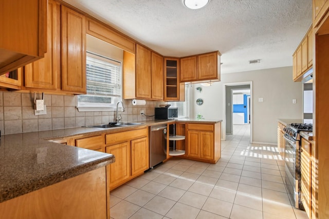 kitchen featuring sink, kitchen peninsula, backsplash, stainless steel appliances, and light tile patterned flooring