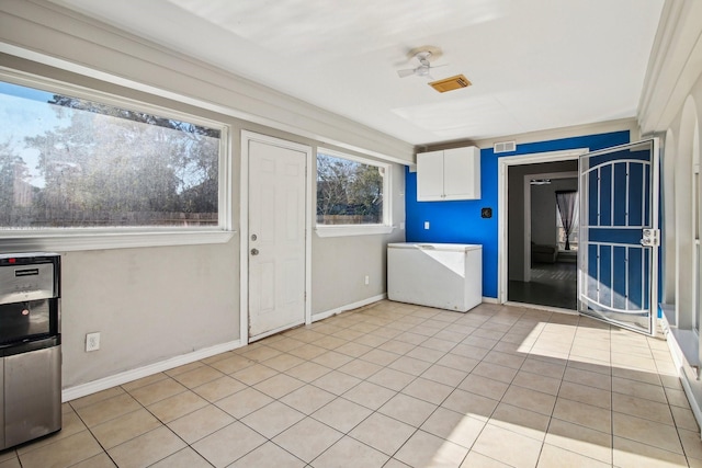 clothes washing area with ceiling fan and light tile patterned floors