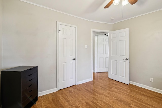 unfurnished bedroom featuring ceiling fan, crown molding, and light wood-type flooring