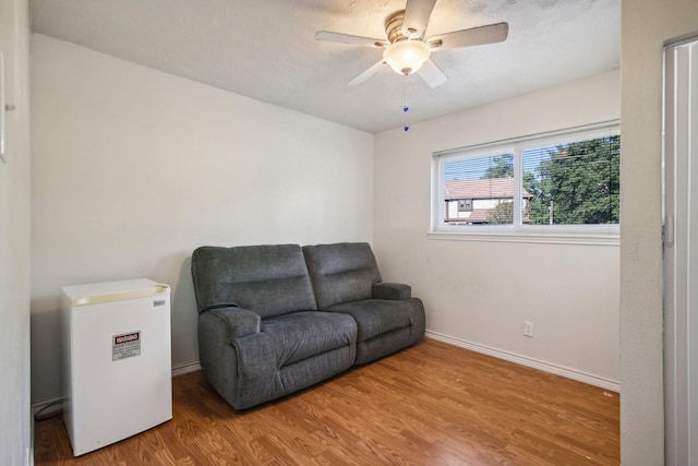 sitting room with hardwood / wood-style flooring and ceiling fan