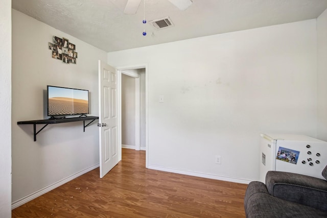 living area featuring wood-type flooring and ceiling fan