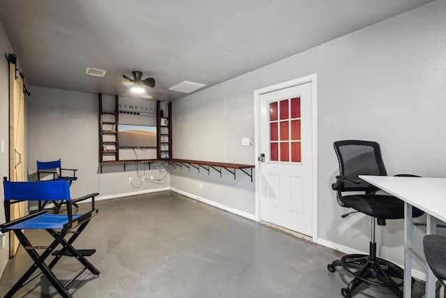 office featuring a barn door and concrete flooring