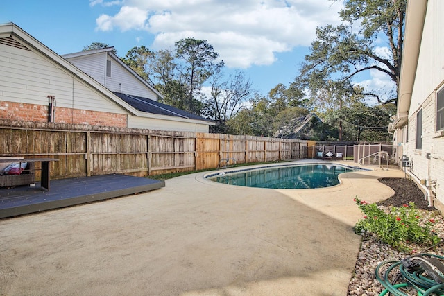 view of pool featuring a patio area and a wooden deck