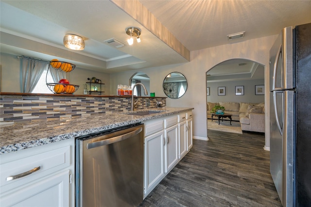 kitchen featuring appliances with stainless steel finishes, sink, white cabinets, and a tray ceiling