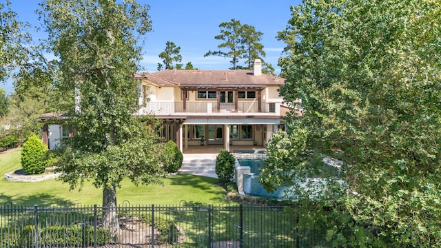 back of property with a balcony, a lawn, and a patio