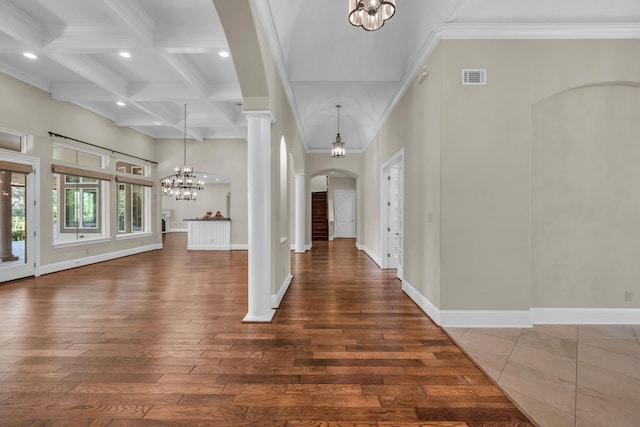 foyer entrance featuring crown molding, beam ceiling, ornate columns, and an inviting chandelier