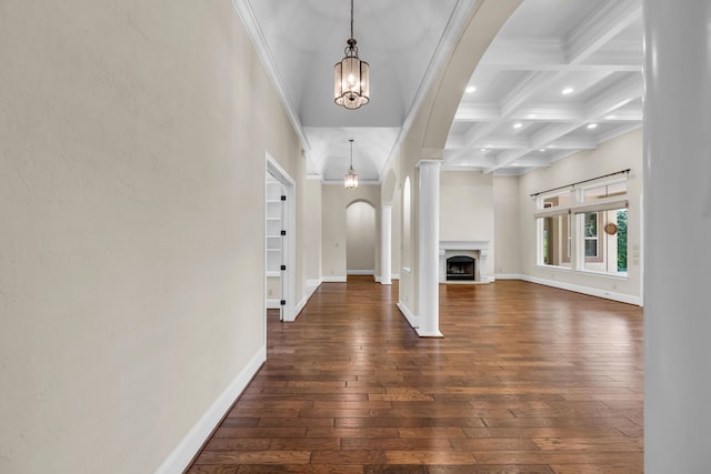 unfurnished living room featuring a notable chandelier, coffered ceiling, beam ceiling, dark wood-type flooring, and ornamental molding