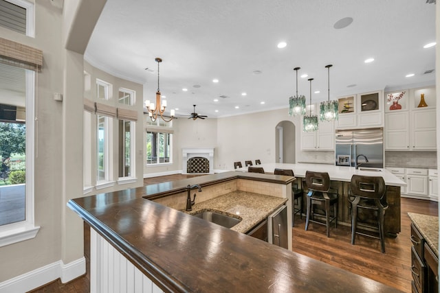 kitchen featuring sink, pendant lighting, built in fridge, and a large island