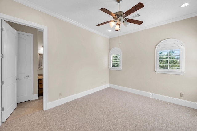 empty room with ceiling fan, light colored carpet, and crown molding