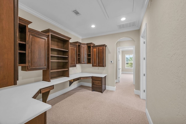 office featuring light colored carpet, ornamental molding, and built in desk