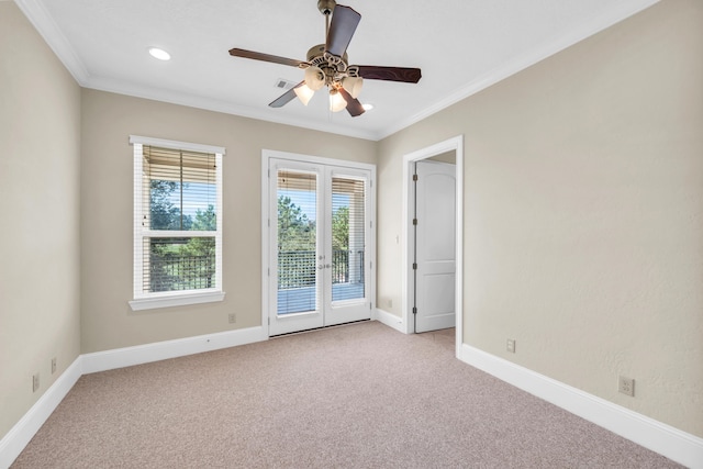 carpeted empty room featuring crown molding, ceiling fan, and french doors