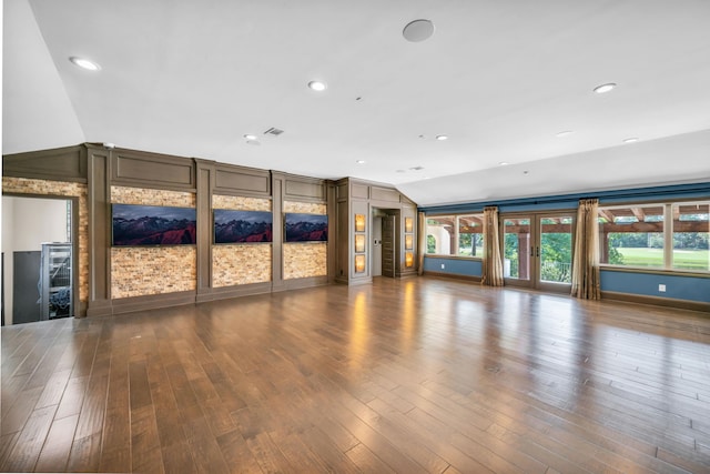 unfurnished living room with dark hardwood / wood-style flooring, french doors, and vaulted ceiling