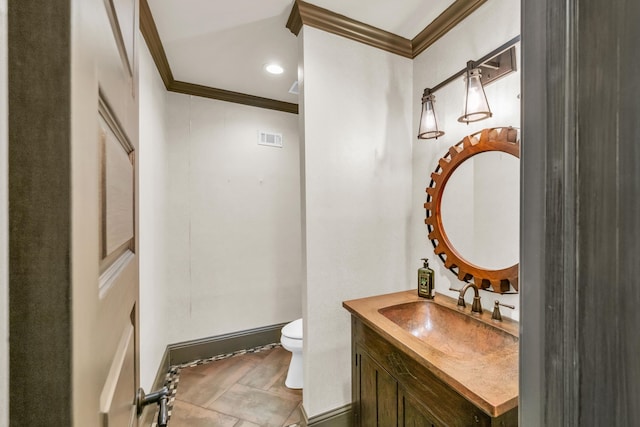 bathroom with toilet, vanity, crown molding, and tile patterned flooring