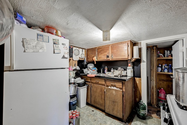 kitchen featuring a textured ceiling and white refrigerator