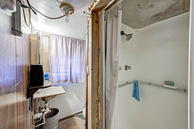 bathroom with a shower with curtain, sink, and a textured ceiling