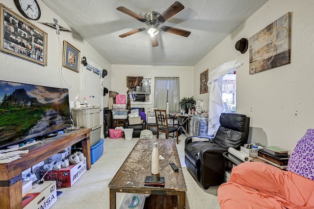 living room featuring ceiling fan and a textured ceiling