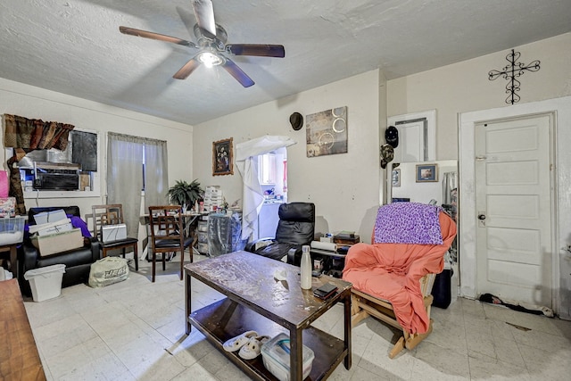 living room featuring ceiling fan and a textured ceiling