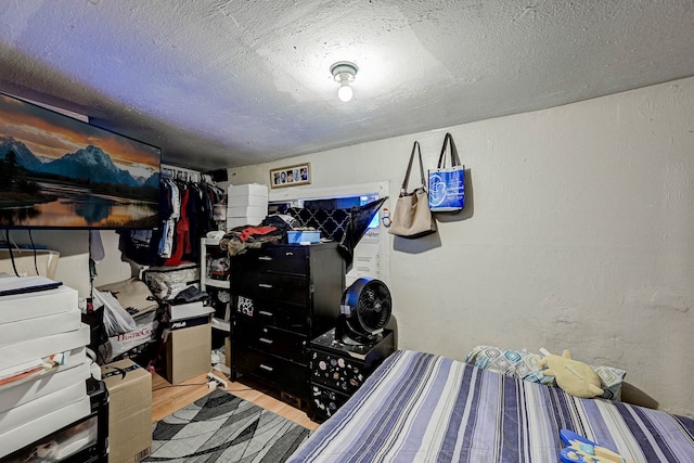 bedroom with light hardwood / wood-style floors and a textured ceiling