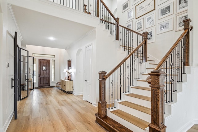 foyer entrance with crown molding and light hardwood / wood-style floors