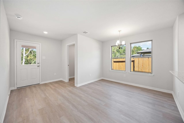 interior space with a notable chandelier and light hardwood / wood-style flooring