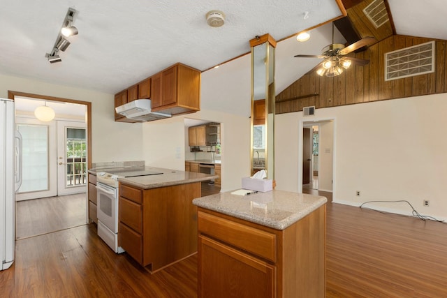 kitchen with a kitchen island, white appliances, dark hardwood / wood-style floors, and lofted ceiling