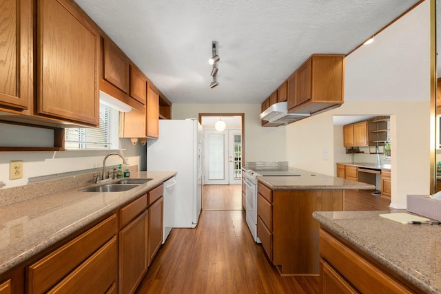 kitchen featuring dark hardwood / wood-style flooring, sink, track lighting, white appliances, and a textured ceiling