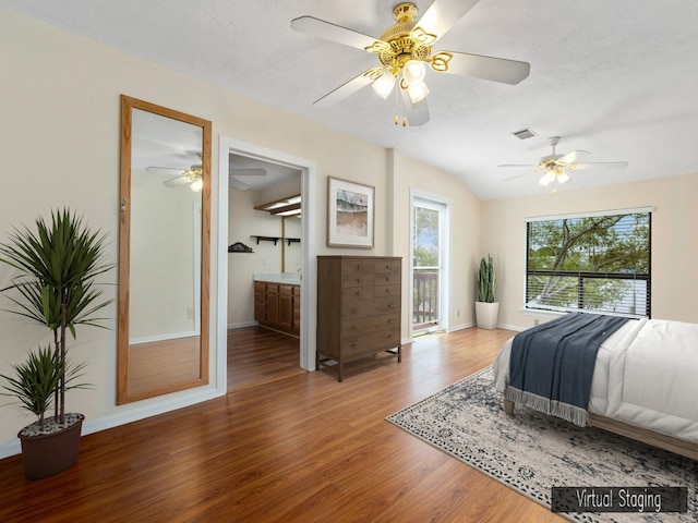 bedroom featuring lofted ceiling, wood-type flooring, access to outside, ceiling fan, and ensuite bathroom