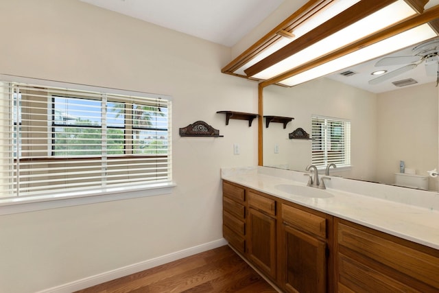 bathroom featuring vanity, hardwood / wood-style flooring, a wealth of natural light, and toilet