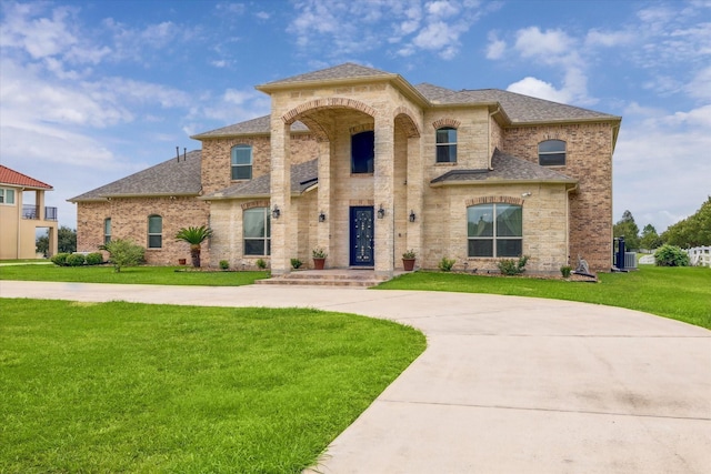 view of front facade with a front yard and central AC