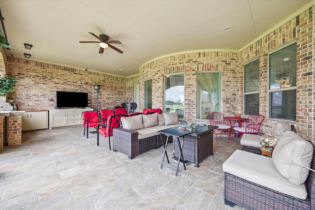 view of patio with ceiling fan, an outdoor kitchen, and an outdoor living space