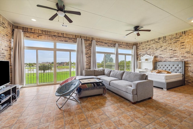 living room featuring ceiling fan and brick wall