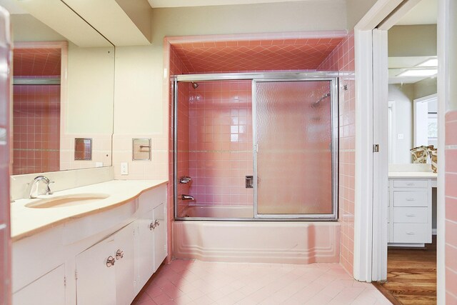 bathroom with shower / bath combination with glass door, vanity, and tile patterned flooring