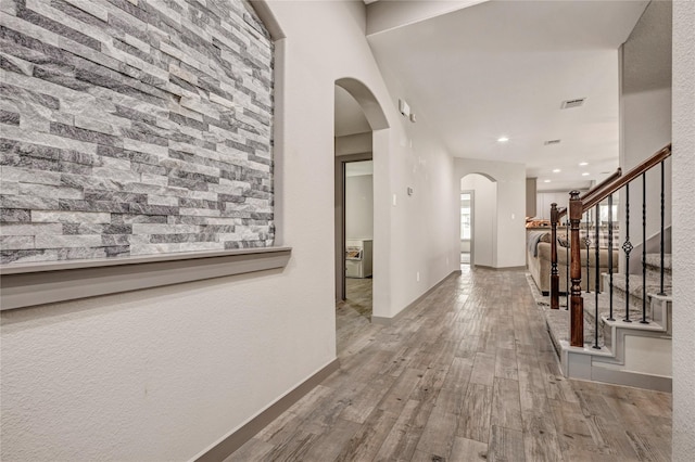 corridor with light hardwood / wood-style flooring and a healthy amount of sunlight