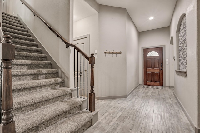 foyer entrance with light wood-type flooring and a high ceiling