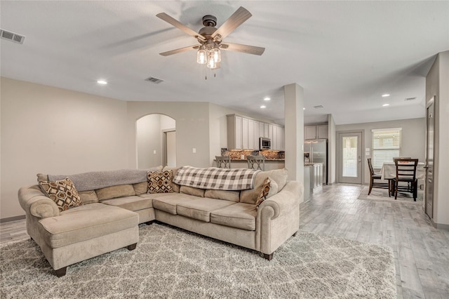 living room featuring ceiling fan and light hardwood / wood-style floors