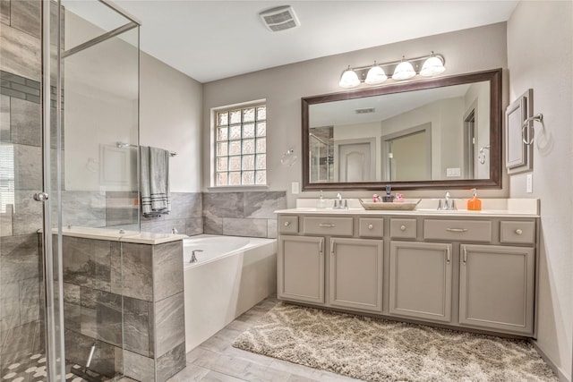 bathroom with vanity and shower with separate bathtub