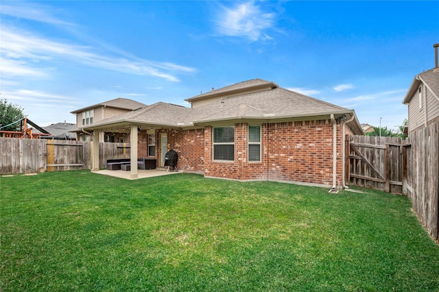 back of house with a patio area and a lawn