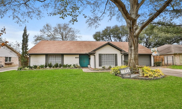 ranch-style home featuring a garage and a front lawn