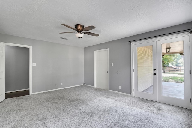 unfurnished room with ceiling fan, a textured ceiling, carpet, and french doors