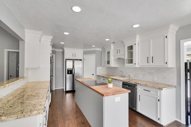 kitchen with a kitchen island, white cabinets, butcher block counters, and stainless steel appliances