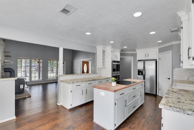 kitchen featuring sink, white cabinetry, appliances with stainless steel finishes, and kitchen peninsula