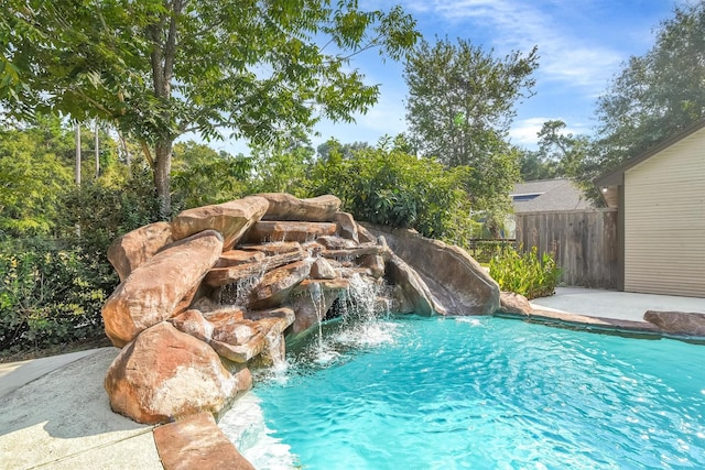 view of swimming pool with pool water feature