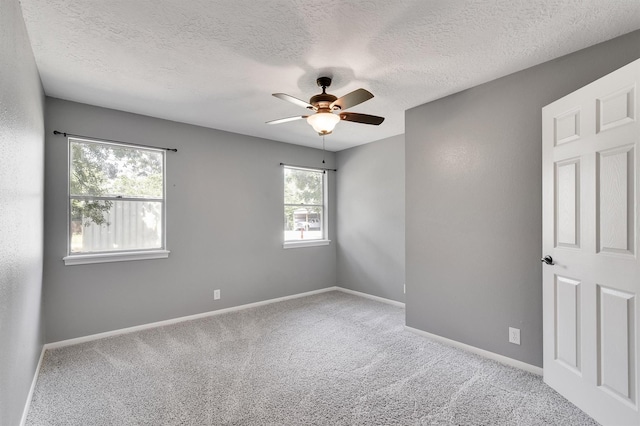 carpeted empty room with ceiling fan and a textured ceiling