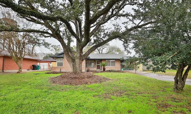 ranch-style house with brick siding, concrete driveway, and a front lawn