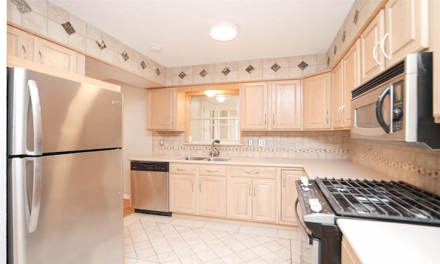 kitchen with light brown cabinetry, sink, light tile patterned flooring, decorative backsplash, and stainless steel appliances