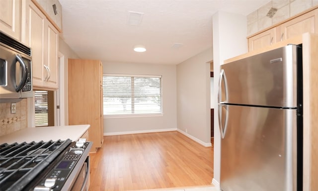 kitchen featuring light wood-type flooring, stainless steel appliances, and light brown cabinetry