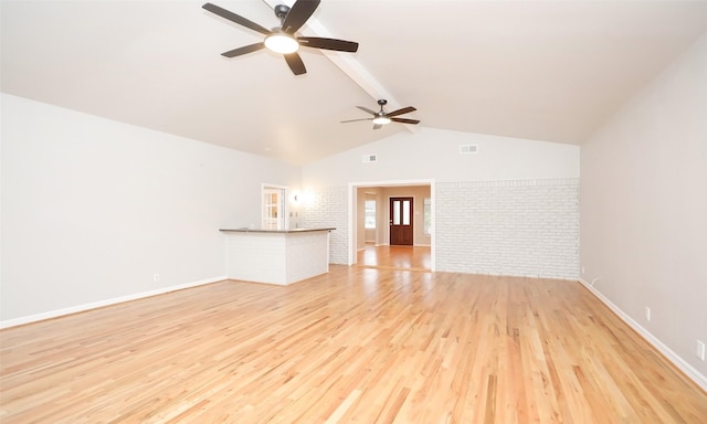 unfurnished living room featuring light wood-type flooring, ceiling fan, brick wall, and vaulted ceiling with beams