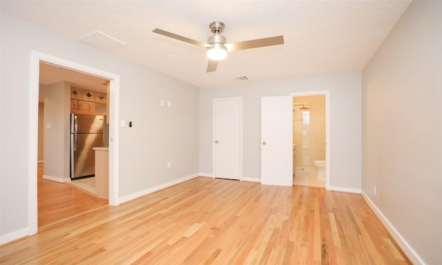 unfurnished bedroom with ceiling fan, connected bathroom, light hardwood / wood-style floors, and stainless steel fridge